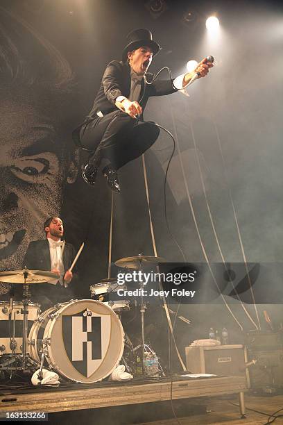 Lead singer Howlin' Pelle Almqvist of The Hives jumps off the drum kit as they perform in concert at The Vogue on March 4, 2013 in Indianapolis,...