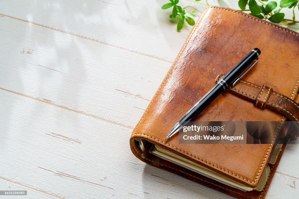 Ring bound planner and pen on wooden table