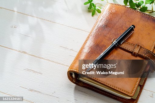 Ring bound planner and pen on wooden table Ring bound planner and pen on wooden table