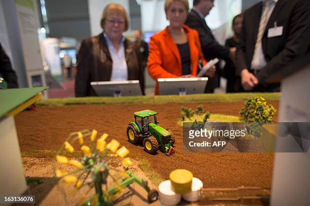 Visitors watch models of electronically controlled tractors during a demonstration at Fraunhofer institute stand at the 2013 CeBIT technology trade...