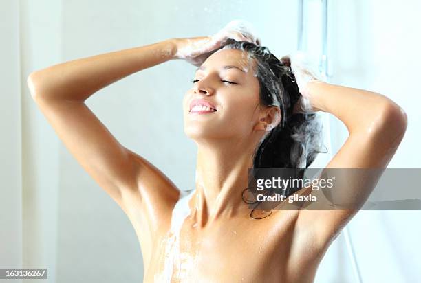 smiling woman under shower. - women washing hair stock pictures, royalty-free photos & images