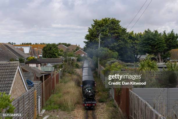 The Romney, Hythe and Dymchurch railway train makes its way between homes along the Kent coast on August 22, 2023 in Dungeness, England.