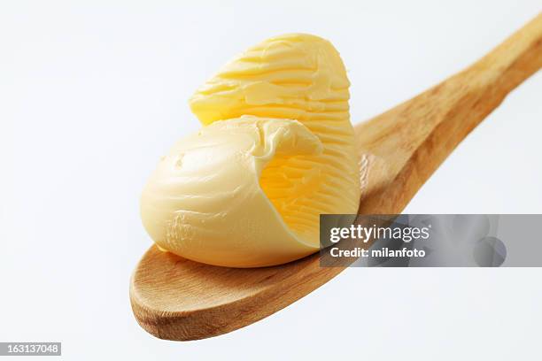 butter curl on a wooden spoon - butter curl stock pictures, royalty-free photos & images