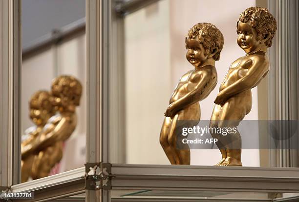 Models of the Mannekin Pis statue stand on a shelf at the stand for Brussels, at the ITB Berlin tourism convention prior to its opening in Berlin on...