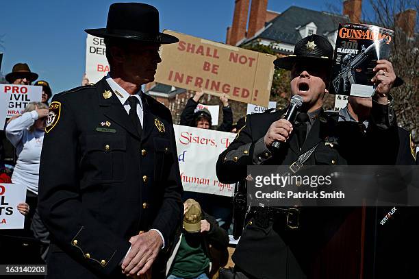 Wicomico County Sheriff Michael A. Lewis holds up his 'Guns & Ammo' magazine as he speaks to other Second Amendment supporters as they rally against...