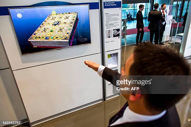 Visitor tests an interactive 3-D boook explorer at Fraunhofer stand at the 2013 CeBIT technology trade fair on March 5, 2013 in Hanover, Germany....