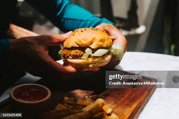 man holding vegan burger with bean patty - vegetable kebab stock pictures, royalty-free photos & images