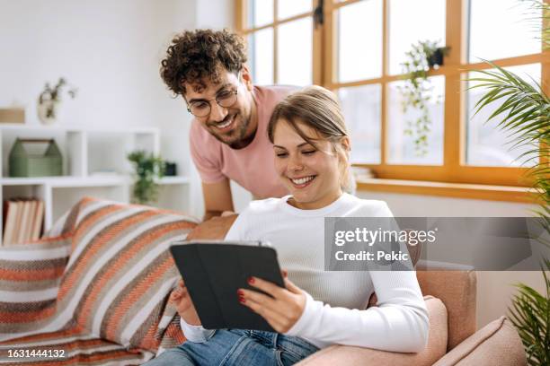 young couple using digital tablet at home - ungt par bildbanksfoton och bilder