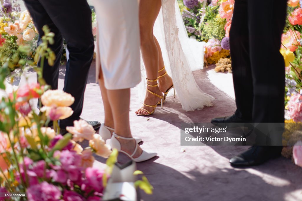 Two couples in the festive clothes surrounded with flowers