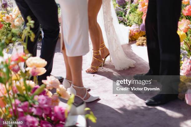 two couples in the festive clothes surrounded with flowers - wedding shoes stock pictures, royalty-free photos & images