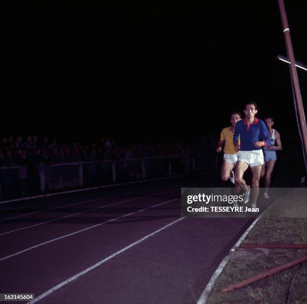 Michel Jazy. En France, Michel JAZY, athl�ète, coureur de demi-fond, portant un maillot jaune, courant lors d'une course de nuit.