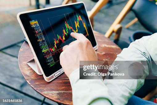 Men's hands and a trading chart on a digital tablet Men's hands and a trading chart on a digital tablet