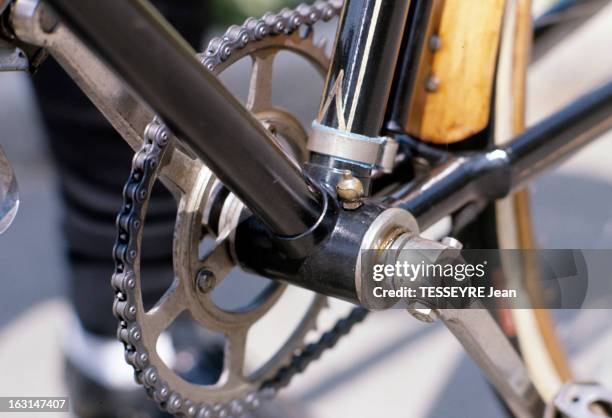 Biclyclettes. Le pédalier d'une bicyclette, équipée d' une jante et d'un garde-boue en bois.