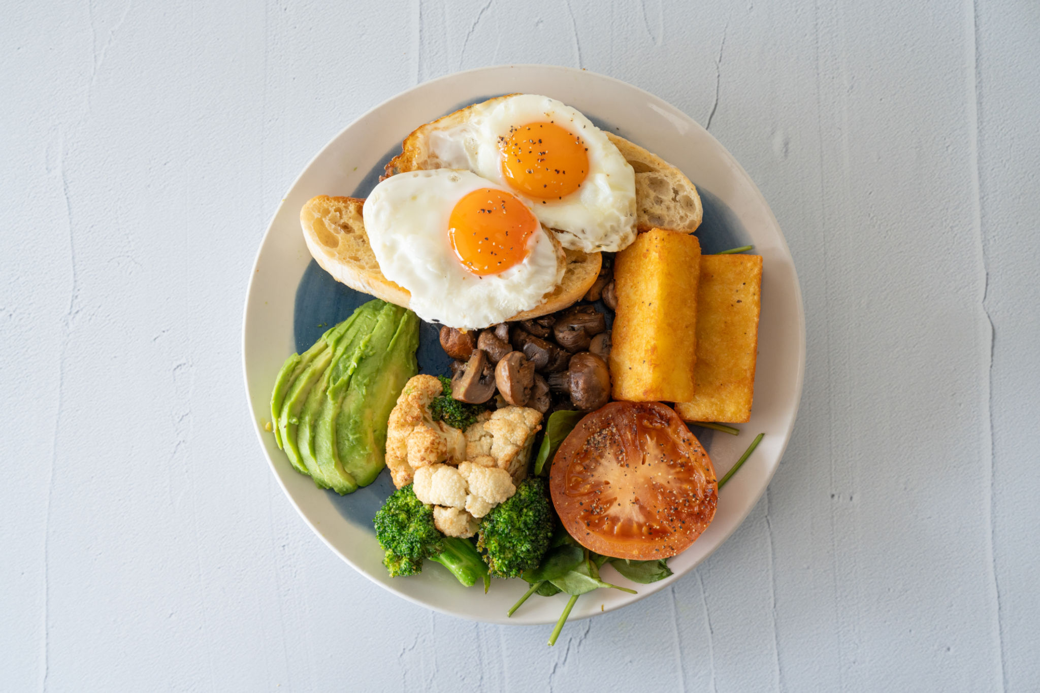 Healthy Breakfast with eggs, avocado, spinach, tomato, broccoli and mushrooms. Healthy Breakfast with eggs, avocado, spinach, tomato, broccoli and mushrooms.