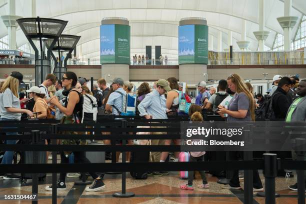 Travelers wait in line at a Transportation Security Administration security checkpoint inside the Jeppesen Terminal at Denver International Airport...