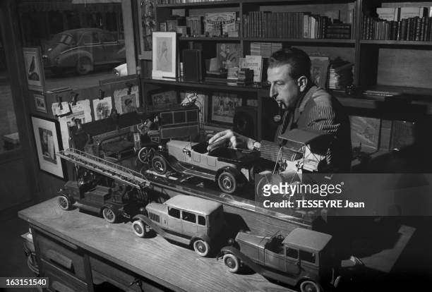 Old Vehicles In Scale Model. En decembre 1958, fumant la pipe devant des rayonnage de livres dans un magasin, un amateur de jouets anciens, devant...