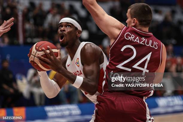 Canada's Shai Gilgeous-Alexander attempts to dunk the ball as Latvia's Andrejs Grazulis defends during the FIBA Basketball World Cup group H match...