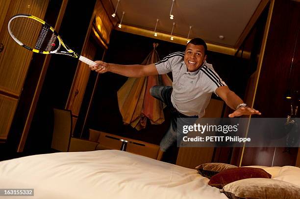 Rendezvous With Jo-Wilfried Tsonga. Attitude souriante de Jo-Wilfried TSONGA en jeans et tee-shirt Adidas, sautant sur le lit d'une chambre de...