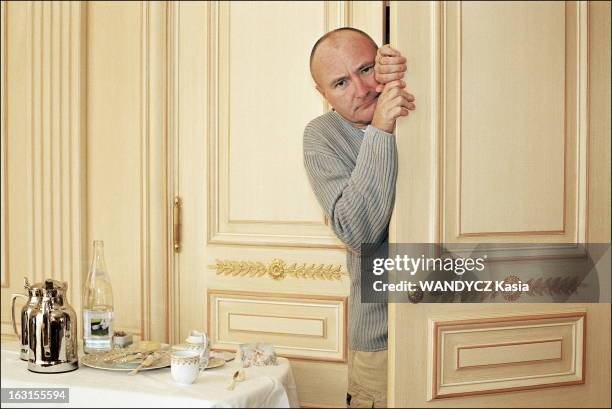 Phil Collins In Paris. Phil COLLINS posant par la porte entrebaillée de sa chambre au Plaza Athénée à Paris..
