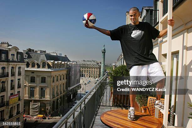 Tony Parker In Paris. Attitude souriante de Tony PARKER un balle de basket dans la main, posant debout sur une table installée sur le balcon de sa...