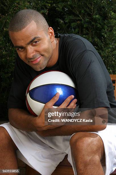 Tony Parker In Paris. Attitude souriante de Tony PARKER serrant contre lui un ballon de basket, assis sur le balcon de sa chambre de l'hôtel Park...