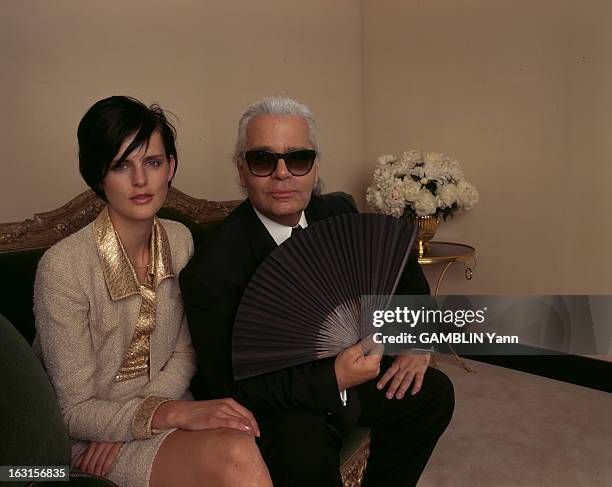 Karl Lagerfeld And Stella Tennant. Juillet 1996, à New York, le couturier Karl LAGERFELD un eventail à la main posant avec Stella TENNANT assise sur...