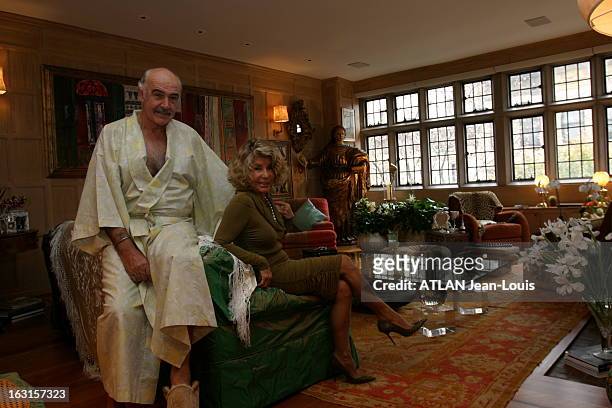 Rendezvous With Sean Connery In New York. Sean CONNERY en kimono blanc et pantoufles posant avec son épouse Micheline dans le salon de leur...