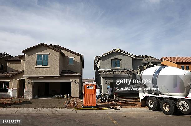 Workers pour concrete for a driveway of a new home at the Pulte Homes Fireside at Norterra-Skyline housing development on March 5, 2013 in Phoenix,...