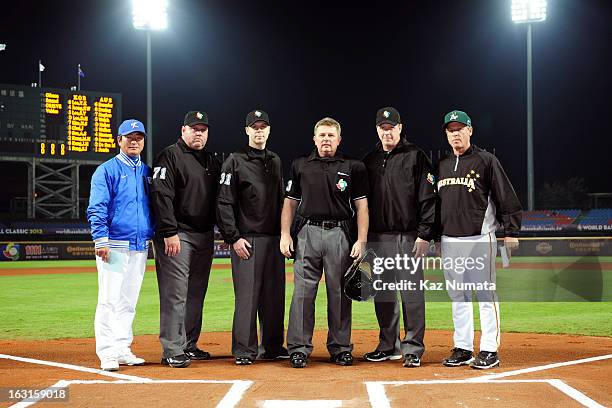 Joong-Il Ryu manager of TEam Korea and Jon Deeble manager of Australia pose with the umpiring crew for a photo before the Pool B, Game 4 between Team...