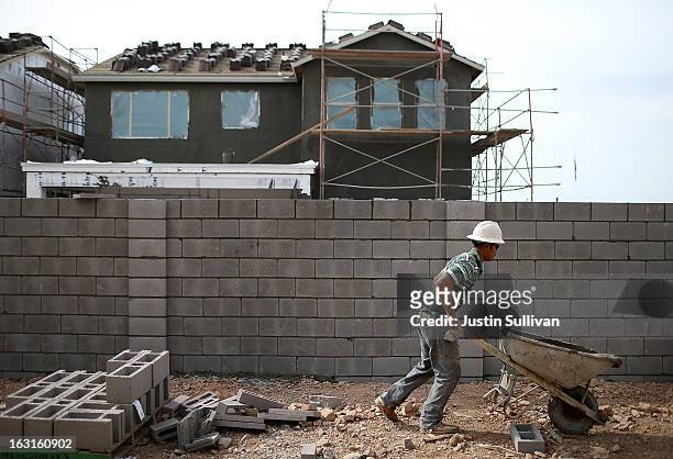 Worker moves concrete at the site of a new home at the Pulte Homes Fireside at Norterra-Skyline housing development on March 5, 2013 in Phoenix,...