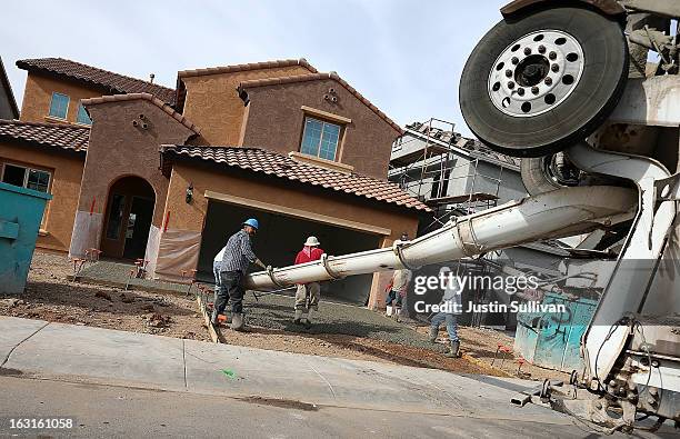 Workers pour concrete for a driveway of a new home at the Pulte Homes Fireside at Norterra-Skyline housing development on March 5, 2013 in Phoenix,...