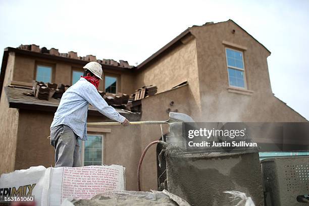 Worker mixes concrete at the site of a new home at the Pulte Homes Fireside at Norterra-Skyline housing development on March 5, 2013 in Phoenix,...