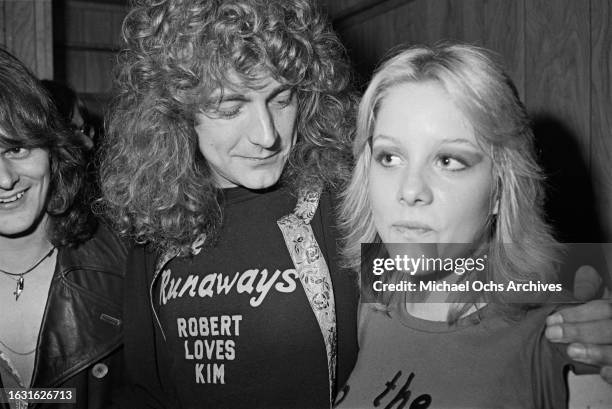 British singer and songwriter Robert Plant, whose t-shirt reads 'The Runaways, Robert Loves Kim', with American singer and musician Cherie Currie at...