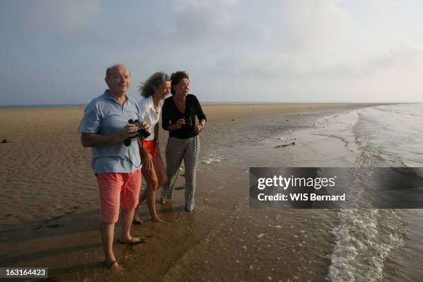 Island Of Re And Celebrities. Sophie DENIAU entre sa mère Lise TOUBON et son beau-père Jacques tenant des jumelles, regardant quelque chose lors...