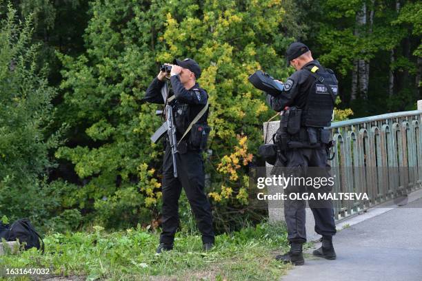 Police officers watch an area near the Porokhovskoye cemetery where Wagner private mercenary group chief Yevgeny Prigozhin, who was killed in a...