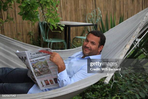 Rendezvous With Bruce Saints On Holiday On Island Of Re. Attitude souriante de Bruce TOUSSAINT lisant le journal 'Le phare de Ré' allongé dans un...