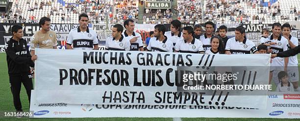 Paraguay's Olimpia football team pose for pictures holding a banner in homage of late Luis Cubilla who passed away on Sunday before their Copa...