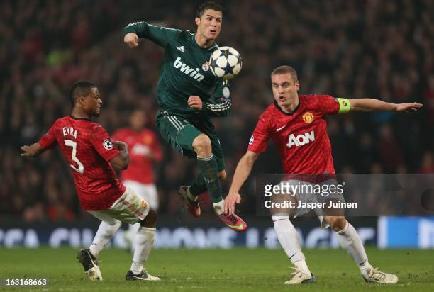 Cristiano Ronaldo of Real Madrid competes with Nemanja Vidic and Patrice Evra of Manchester United during the UEFA Champions League Round of 16...