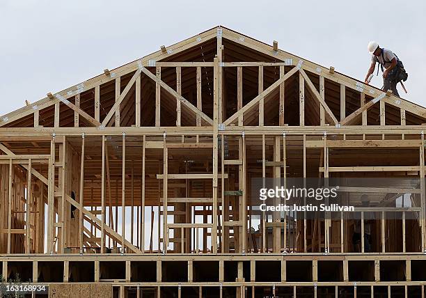 Worker climbs on the roof of a home under construction at the Pulte Homes Fireside at Norterra-Skyline housing development on March 5, 2013 in...