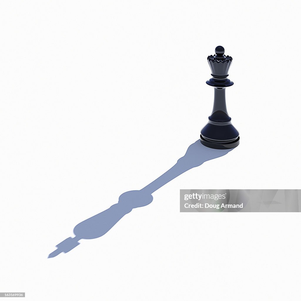 Queen chess piece casting shadow of King