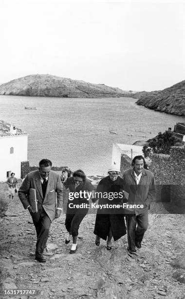 Walt Disney et Salvador Dali se promenant avec leurs épouses à Portlligat, le 9 octobre 1957.