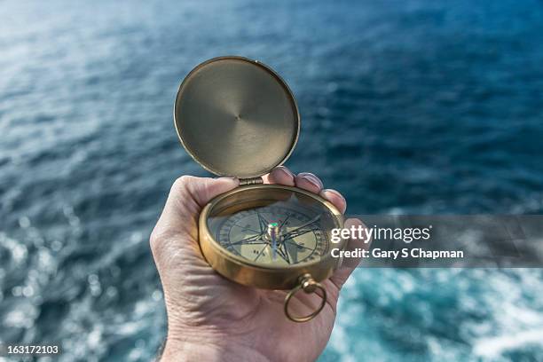 antique brass compas and ocean - navigational compass stock-fotos und bilder