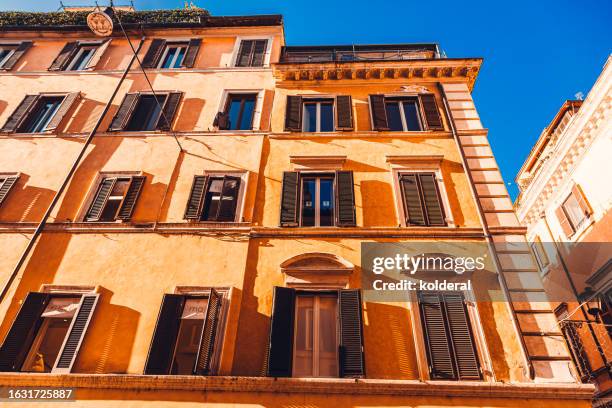 low angle view of typical old residential buildings in historic district of rome, italy - jalousie fotografías e imágenes de stock