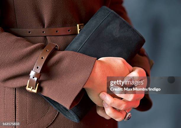 Catherine, Duchess of Cambridge holds her clutch bag as she visits Peaks Lane Fire Station whilst carrying out a day of engagements on March 5, 2013...