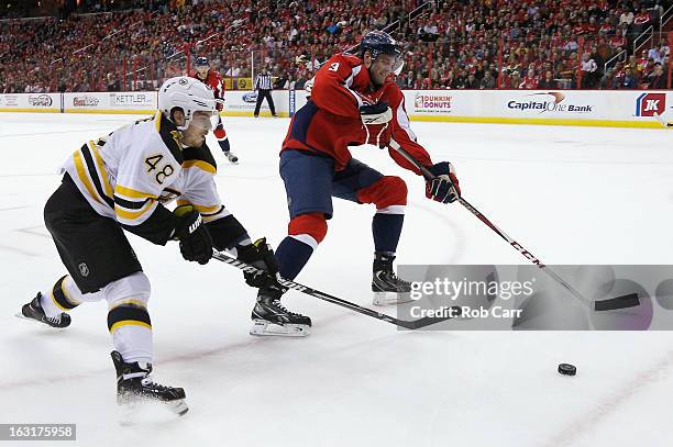 Chris Bourque of the Boston Bruins works the puck against Tom Poti of the Washington Capitals during the second period at Verizon Center on March 5,...