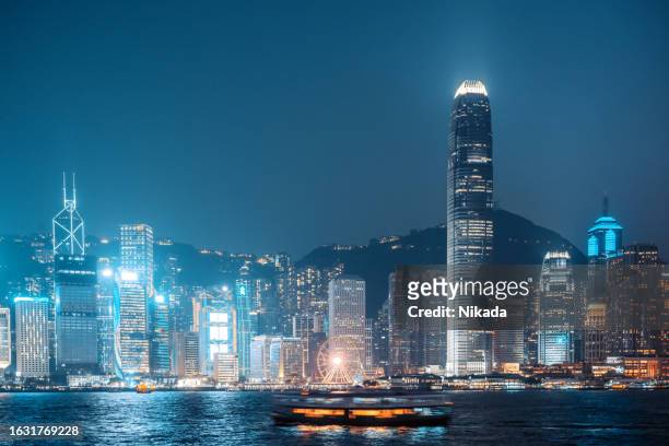 hong kong skyline at dusk with ferry, view from avenue of stars at kowloon. - kowloon walled city stock pictures, royalty-free photos & images