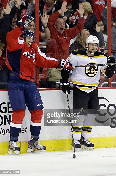 Eric Fehr of the Washington Capitals celebrates in front of Dennis Seidenberg of the Boston Bruins after scoring the game winning goal in overtime to...
