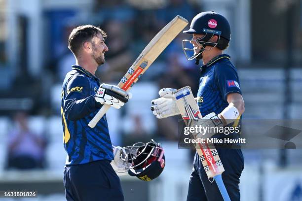 Ed Barnard of Warwickshire celebrates with batting partner Ethan Brookes after reaching his century during the Metro Bank One Day Cup match between...
