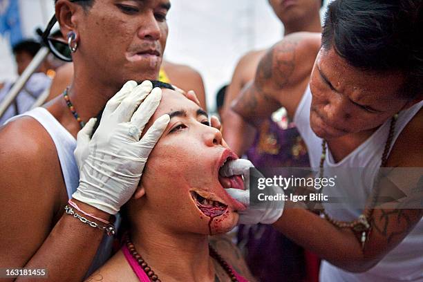 This religious devotee has had his one cheek pierced and his teeth are visible trought the hole. His second cheek is just being pierced. Vegetarian...