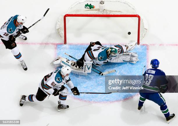 Henrik Sedin of the Vancouver Canucks beats Antti Niemi of the San Jose Sharks for a goal while Matt Irwin and Joe Thornton of the Sharks watch...